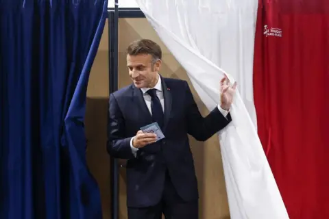 MOHAMMED BADRA/AFP France's President Emmanuel Macron exits a polling boothat a polling station in Le Touquet, northern France 