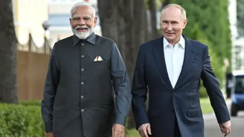 Getty Images TOPSHOT - In this photo released by the Russian state agency Sputnik, Russian President Vladimir Putin and Indian Prime Minister Narendra Modi walk during an informal meeting in the residential area of ​​Novo-Ogaryovo region, outside Moscow , July 8, 2024. (Photo by Sergey BOBYLYOV / POOL / AFP) (Photo by SERGEI BOBYLYOV/POOL/AFP via Getty Images)