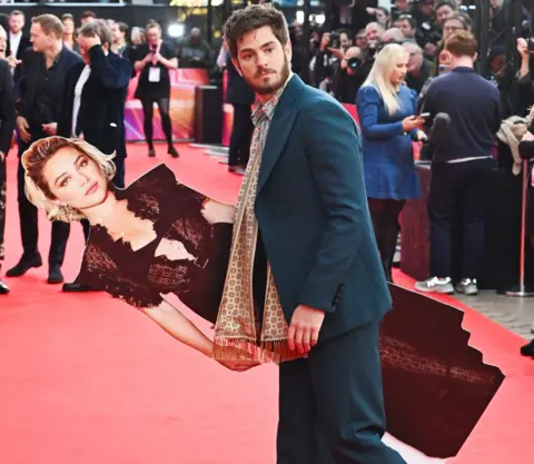 Getty Images Andrew Garfield (po prawej) pozuje z tekturową wycinką Florence Pugh podczas gali Headline "Żyjemy w czasie" podczas 68. BFI London Film Festival w The Royal Festival Hall 16 października 2024 r. w Londynie, Anglia