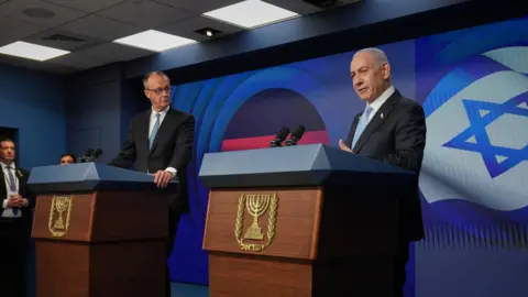 Reuters Israeli Prime Minister Benjamin Netanyahu (R) speaks during a joint press conference with German Chancellor Friedrich Merz in Jerusalem (7 December 2025)