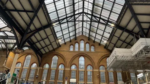 A roof full of glass panels with some scaffolding to one side.