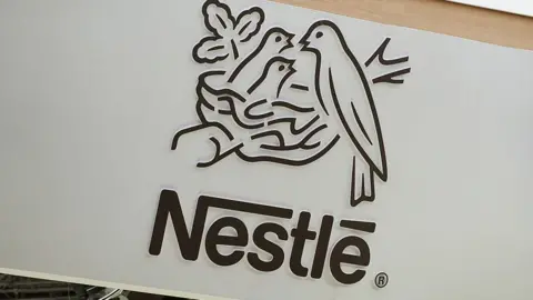 Getty Images The Nestle logo, featuring a bird feeding its two chicks in a nest. 