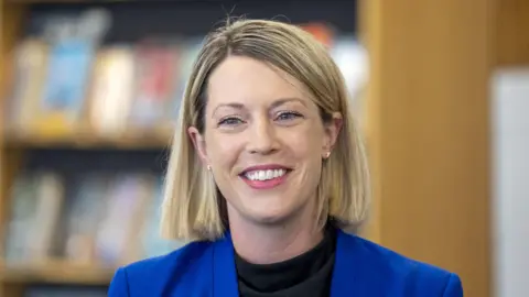 PA Media Jenny Gilruth with blonde hair and a blue suit jacket head and shoulders shot.