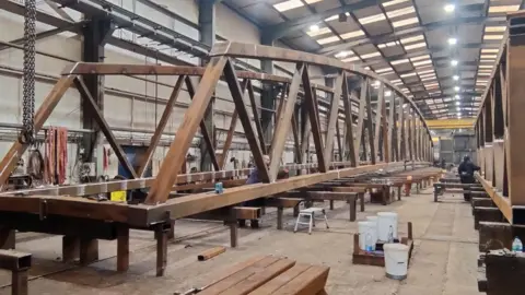 A large part of a bridge in a warehouse. 