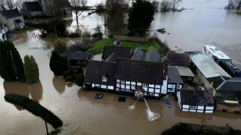 Aeriel view of the village of Severn Stoke surrounded by muddy flood water
