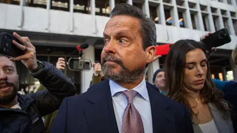 Getty Images Attorney Alan Jackson, surrounded by journalists, looks to the left as he exits the courthouse during Nick Reiner's arraignment