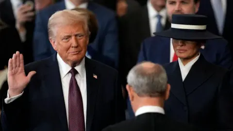 Getty Images Donald Trump is sworn in as the 47th president of the United States by Chief Justice John Roberts as Melania Trump holds the Bible in the US Capitol Rotunda in Washington, DC