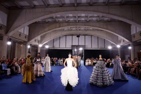Benjamin Cremel/Getty Images Models walk the runway during the Alexis Mabille Haute Couture Fall/Winter 2026/2027 show as part of Paris Fashion Week on July 07, 2026 in Paris, France. 