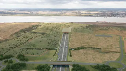 National Highways A computer-generated aerial image of what the motorway leading into a new tunnel under the Thames could look like. In the middle of the image, a four-lane motorway runs towards the tunnel entrance. The Thames can be seen in the distance, as well as the countryside on the other side. The new road is surrounded on either side by fields.