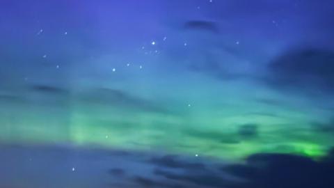 The night sky, streaked with green aurora
