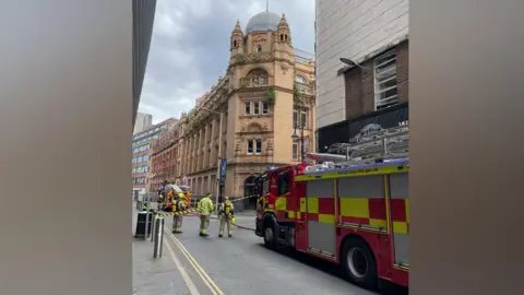 Fire crews outside an ornate four storey building on an urban street