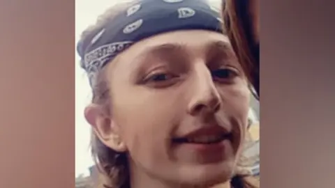 Bedfordshire Police Jacob Clark with shoulder-length hair. He is wearing a bandana around his forehead.