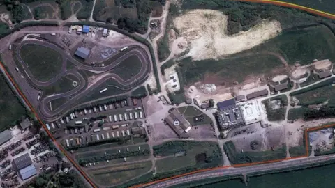 Google Google Earth aerial image shows the development area, encomapassing the raceway, caravan park, various other structures and a large area of bare, chalky ground.