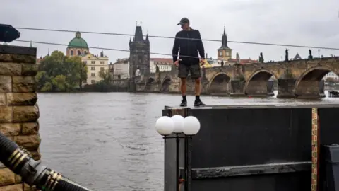  MARTIN DIVISEK/EPA-EFE/REX/Shutterstock A worker prepares to close a floodgate on the Vltava river in downtown Prague, Czech Republic, September 13, 2024