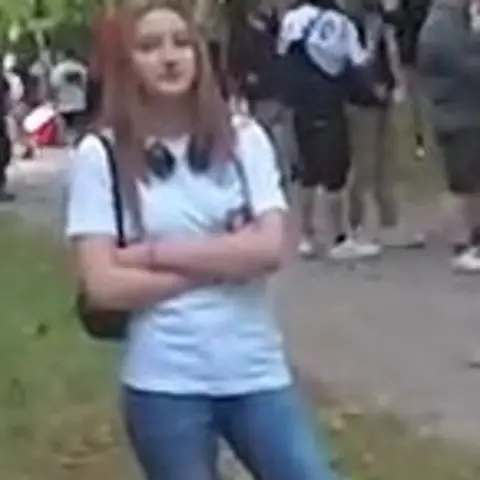 Avon and Somerset Police A woman stood with her arms folded with headphones around her neck