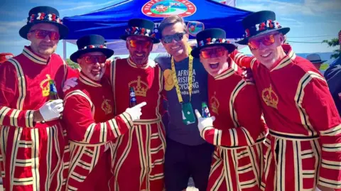 Friends dress as Beefeaters to cheer on cyclists