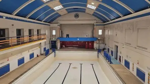 An empty swimming pool with blue and white paint