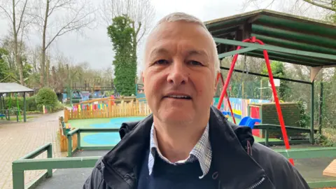 BBC A picture of Jim Wilks, who is standing in front of part of the adventure playground.