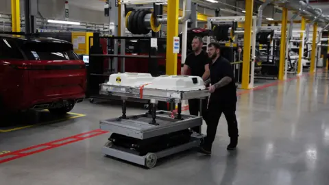 Reuters Engineers push an electric vehicle battery unit