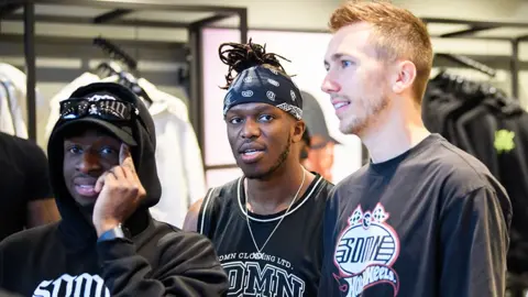 Getty Images Members of the Sidemen are together. KSI is in the middle wearing a black vest top and a black bandana. 