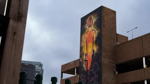 Part of a car park site has been painted to show an illuminated Brit Award in orange. 