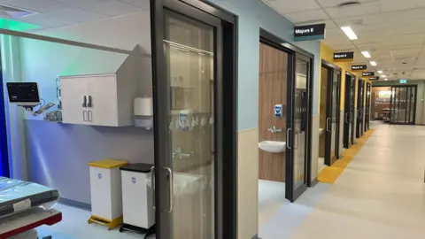 BBC A corridor with patient treatment cubicles next to them