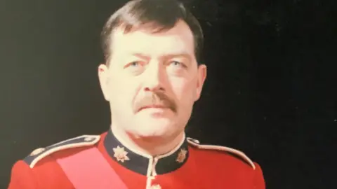British Army/Geoff Dakin Veteran Geoff Dakin in red Coldstream Guards uniform
