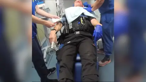 Police officer unconscious in hospital.