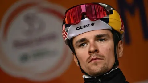 Tom Pidcock wearing a cycling helmet and sunglasses