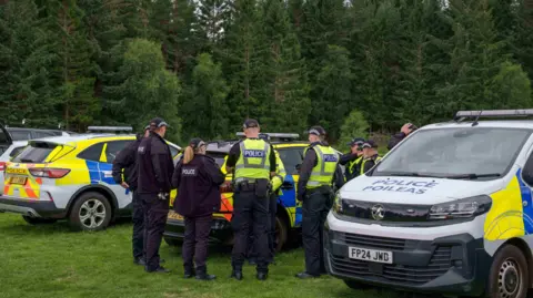 JasperImage several police officers and vans near woods