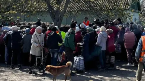 People in Oleshky gather for food delivery