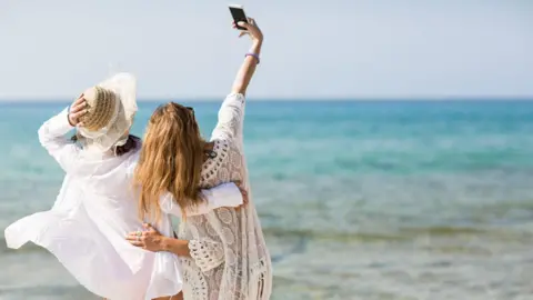 Getty Images Two women taking a selfie 