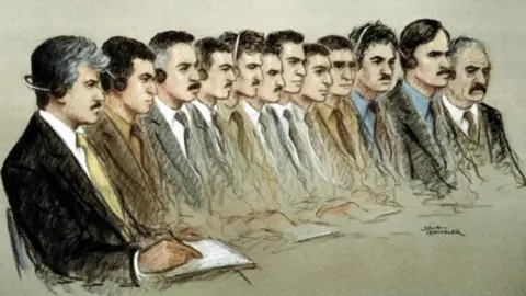 Julia Quenzler/BBC Court sketch shows 12 men, all smartly dressed in jackets, shirts and ties, sitting down. Some are writing in notebooks and some are wearing earphones.