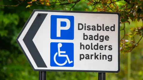 Getty Images A road sign that reads "disabled badge holders parking".