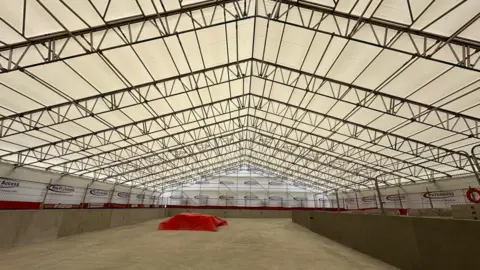 Portsmouth City Council Large concrete walled pool area with red sheet towards on end - it is covered in a scaffold structure and white plastic sheeting
