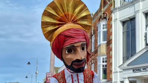 Giant head of a puppet in a turban