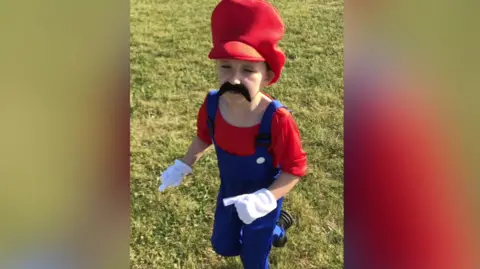 Ollie A young person in a Super Mario fancy dress outfit.