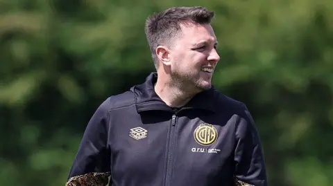 Getty Images A smiling Mark Bonner at the club's training ground wearing a black tracksuit top with the club badge on