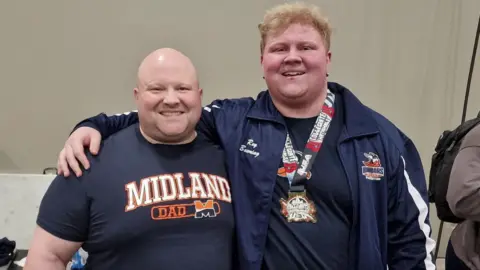 Ray Bowring Dean and Ray Bowring posing with arms around each other's shoulders, Ray has his medal around his neck
