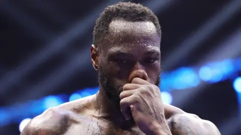 Deontay Wilder holds his nose and loos into the distance