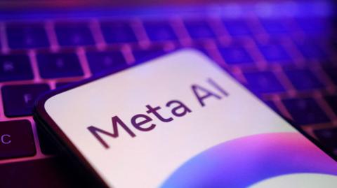 Meta AI logo is displayed on a smartphone lying on a computer keyboard