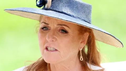 Sarah Ferguson Duchess of York attends day two of Royal Ascot 2024 at Ascot Racecourse on June 19, 2024 in Ascot, England, wearing a white and blue sun hat and gold earrings