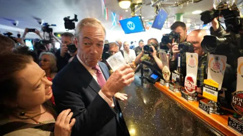 PA Media Nigel Farage holding a beer glass