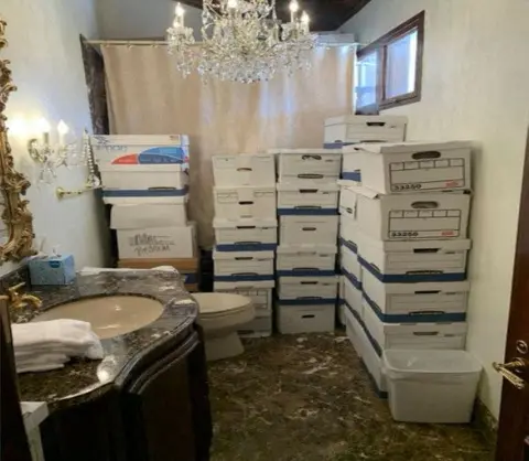 Reuters Dozens of white boxes are piled up in a bathroom with a sink, toilet, shower and ornate fittings including a chandelier 