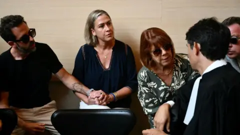 CHRISTOPHE SIMON/AFP Gisèle Pelicot (C-R) speaks to one of her lawyers, beside her daughter Caroline Darian (L) and her sons Florian Pelicot (L) and David Pelicot (R)