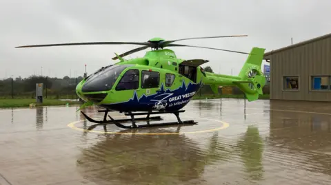 Green and blue Great Western Air Ambulance waiting for lift off 