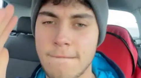 Norfolk Constabulary A close-up selfie shot of a young man wearing a grey hat while sitting in a car