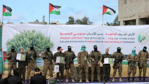 The Israeli hostages of Reuters, Omer Shem Tov, Eliya Cohen and Omer Wenkert, along with armed Palestinian fighters during a delivery ceremony in Nuseirat, Central Gaza (February 22, 2025)