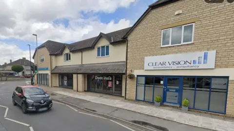 Google Newlands Road with a car driving towards the camera. A Dominos takeaway can be seen on the right in between two other shops.