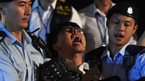 Getty Johsua Wong screams as he is detained at a pro-democracy protest 